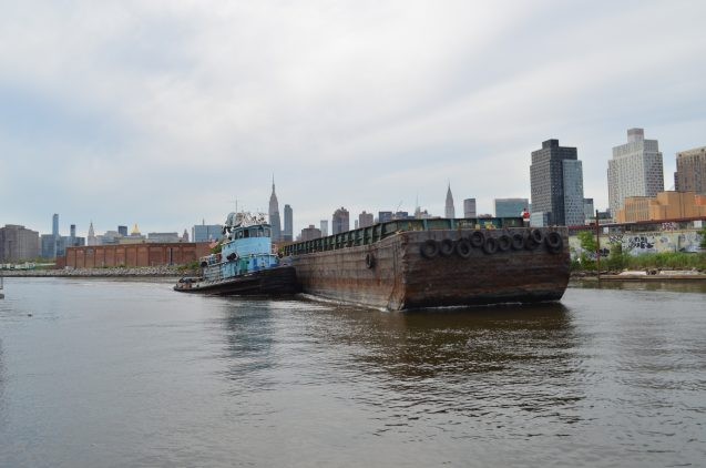 A tug moves an empty barge up Newtown Creek.