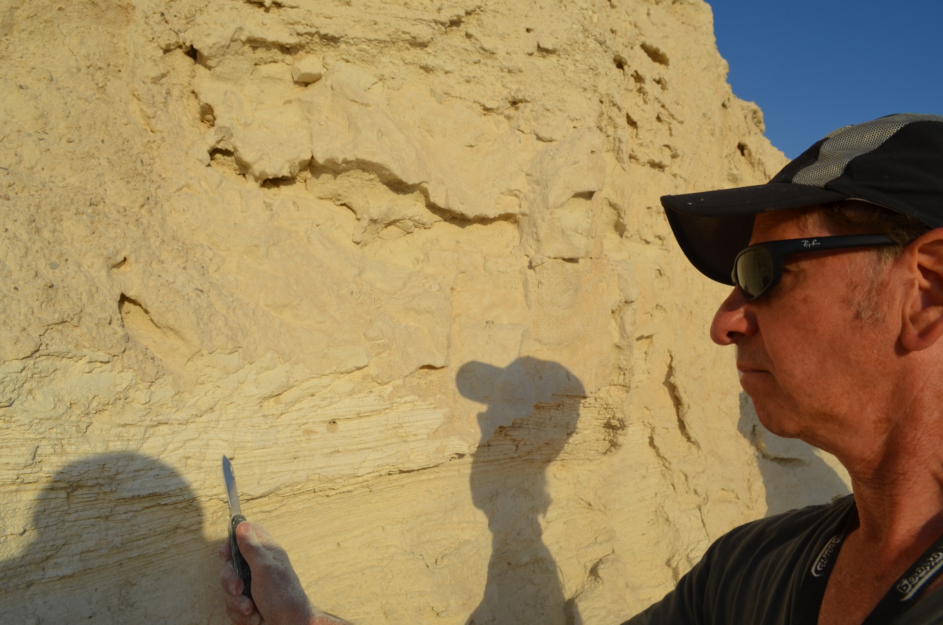 Geoscientist Steven Goldstein of Lamont-Doherty Earth Observatory scrapes at sediments from a long-gone seabed, part of a study on past megadroughts being carried out in Israel and Jordan.