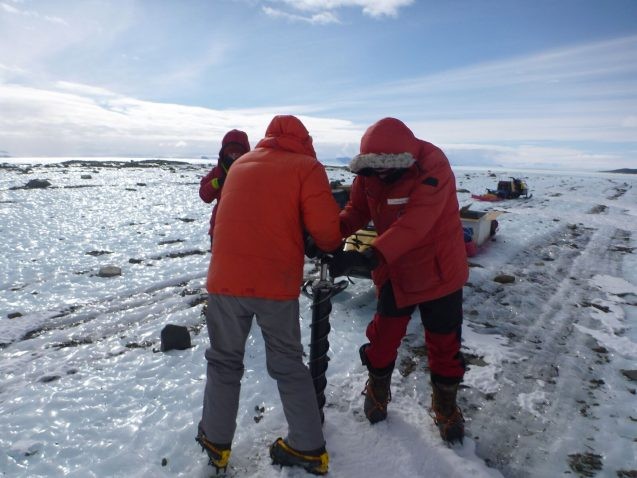 Team members taking a short ice core to study properties of sediment coming from the East Antarctic ice sheet. (Photo: Mike Kaplan)