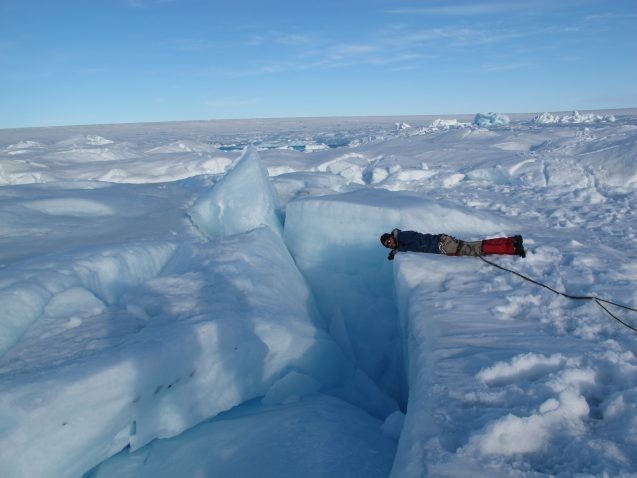 A researcher investigates a channel in the Greenland ice