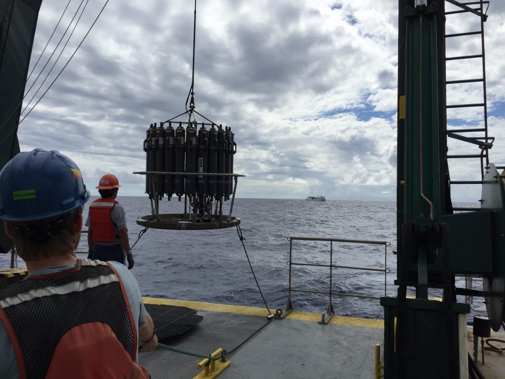 water sampling device is lowered off the ship into the ocean