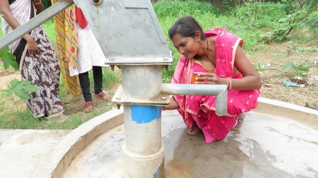 woman in india painting well pump