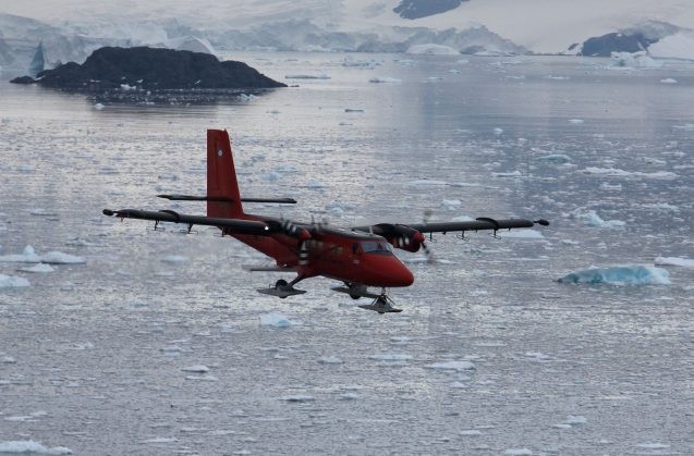 small plane flying over icy water