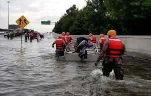 soldiers move through flooded street