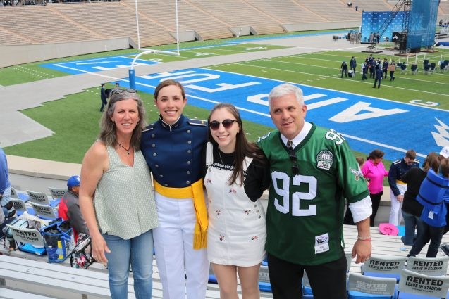 family photo in front of football field