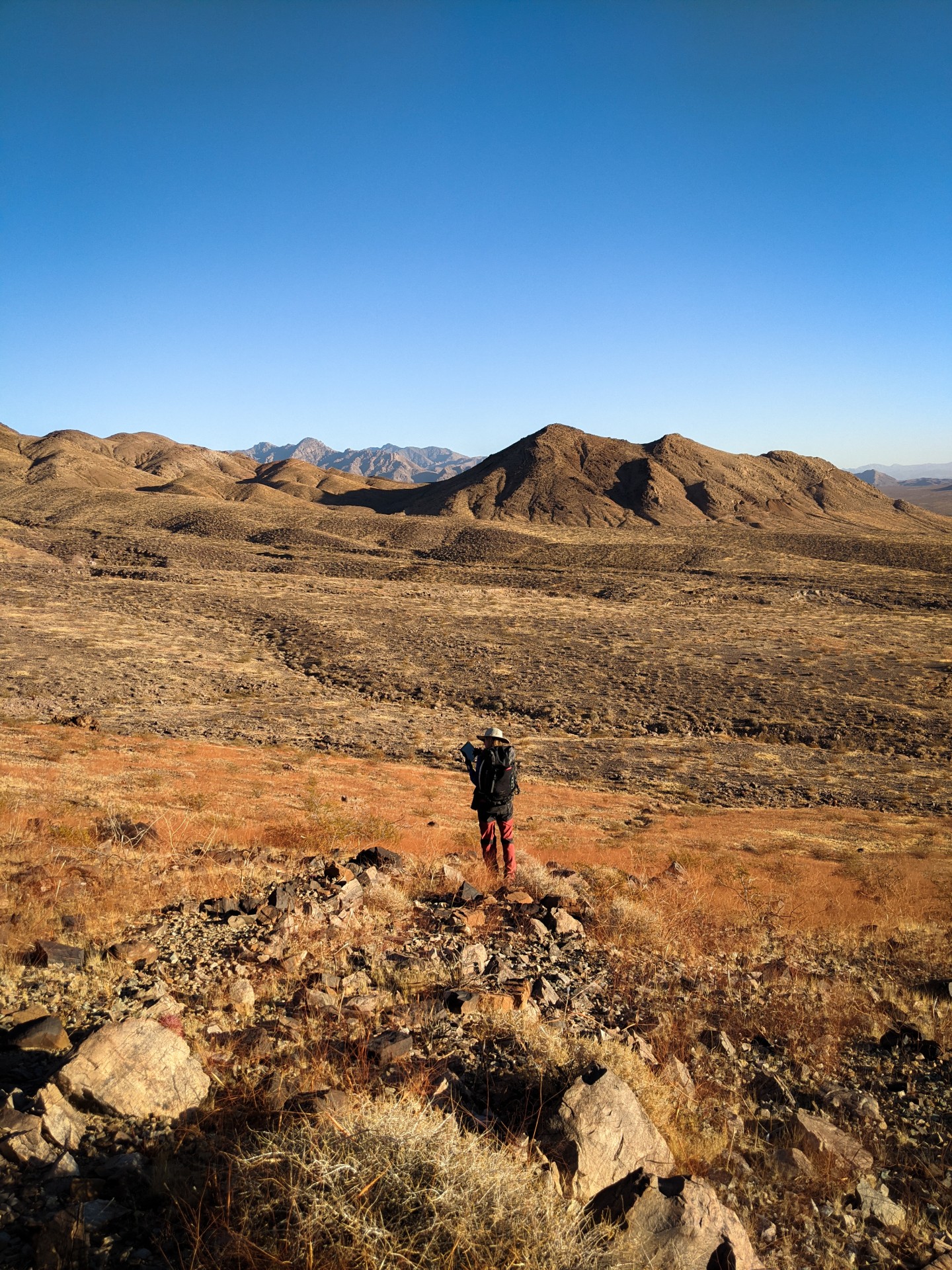 Sarah Giles, a PhD student at Lamont-Doherty Earth Observatory, conducting geologic fieldwork in eastern California. The rocks Giles is studying are about 580 million years old, and the environment they formed in remains up for debate. The rocks formed at a time in geologic history when large animals began to appear in the fossil record, and when major reorganizations in Earth's carbon cycle were potentially occurring. Photo: Sarah Giles PXL_20201202_232402305 - Sarah Giles