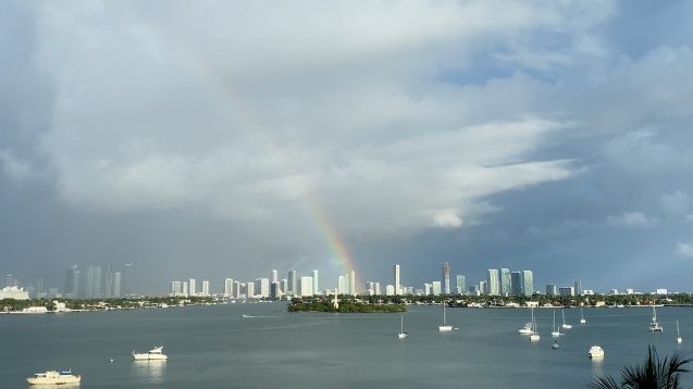 rainbow over tall buildings across biscayne bay