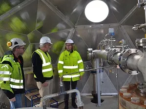 Inside the injection shed at Carbon injection site, Hellisheidi geothermal power plant. CarbFix project manager Edda Sif Aradottir (right) inspects the installation with Lamont-Doherty hydrologist Martin Stute and chemical engineer Magnus Thor Arnarson. Credit: Kevin Krajick/Earth Institute