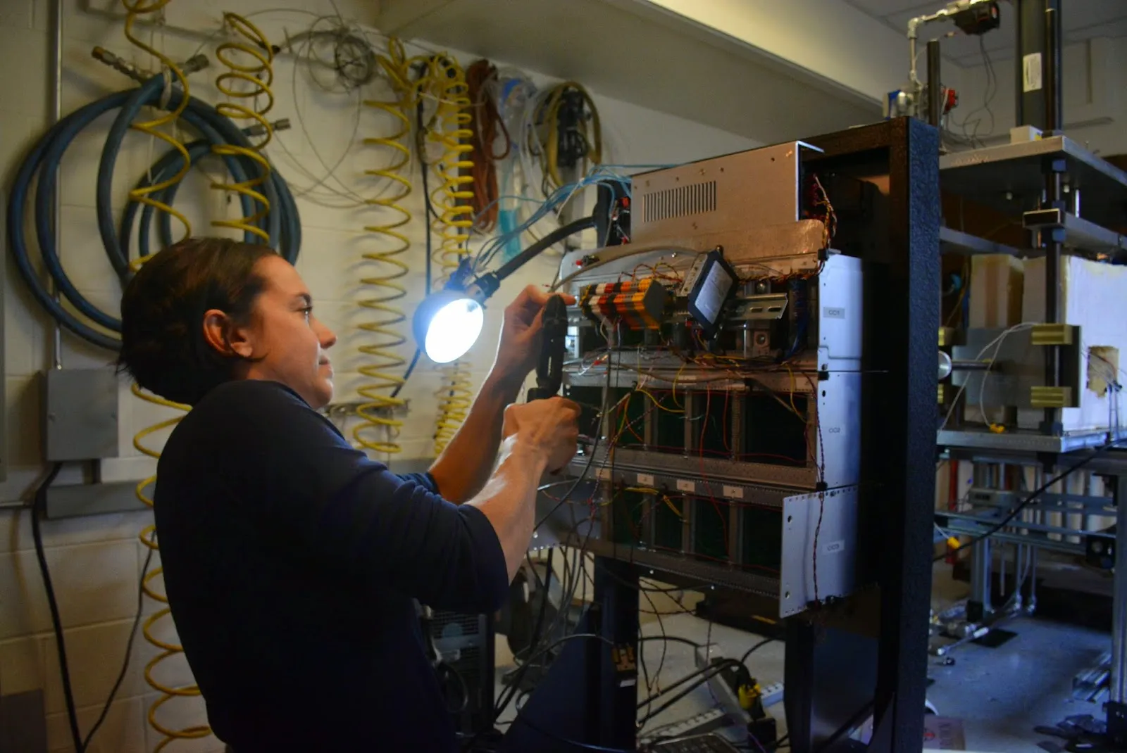 Christine McCarthy works on some of the wiring for her custom cryogenic biaxial apparatus (2015).