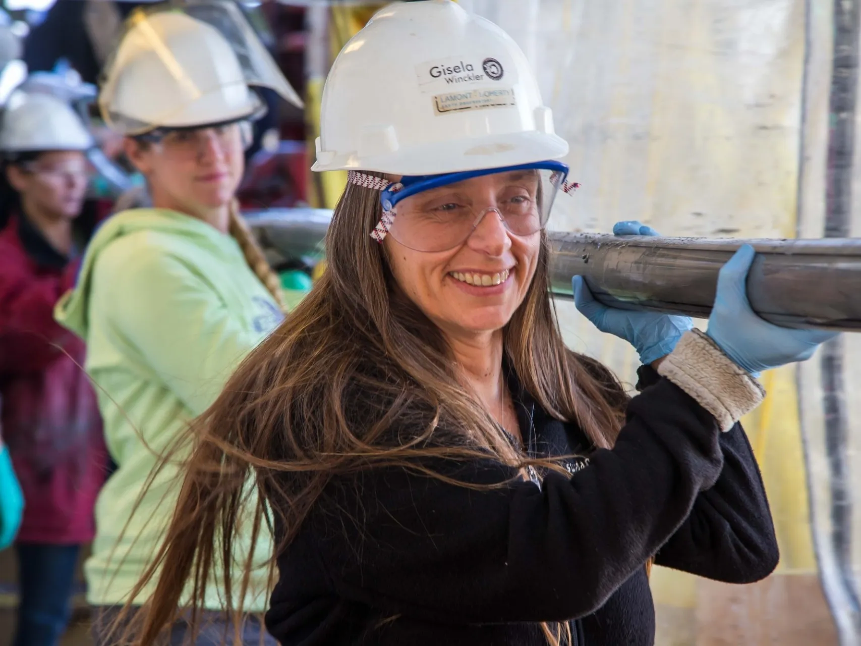 Gisela Winckler carrying sediment core on catwalk of Joides Resolution. Credit: Tim Fulton, IODP