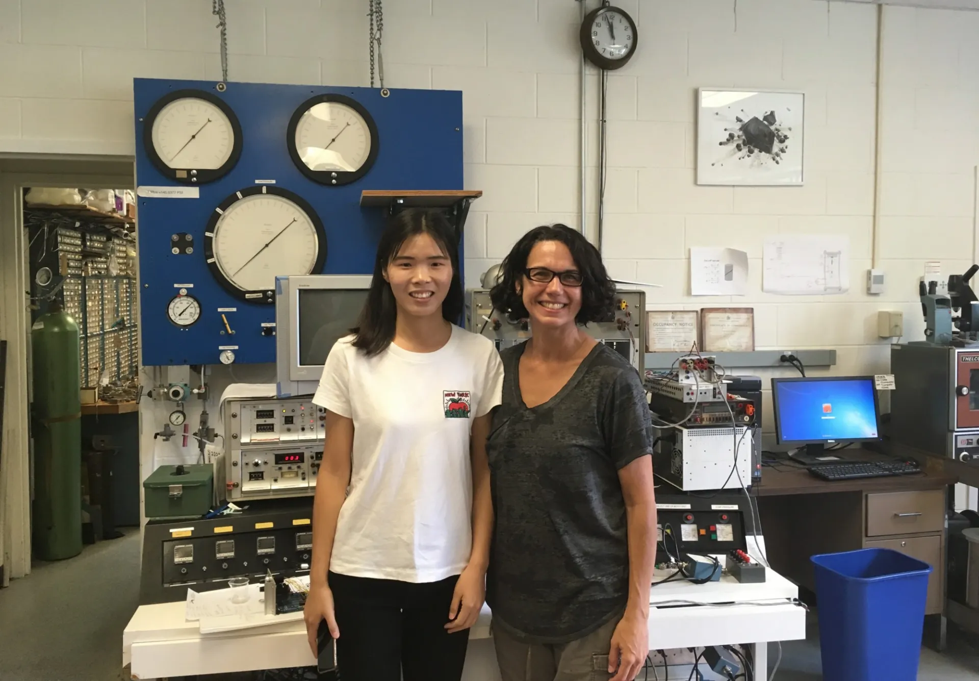 Visiting researcher Daning Zhong and Christine McCarthy pose in front of the triax control panel (2018).