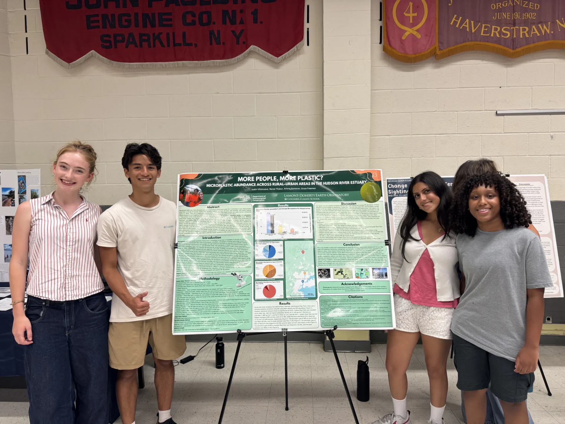 Next Gen interns Ariana, Justin, Grace and Renae standing in front of their research poster