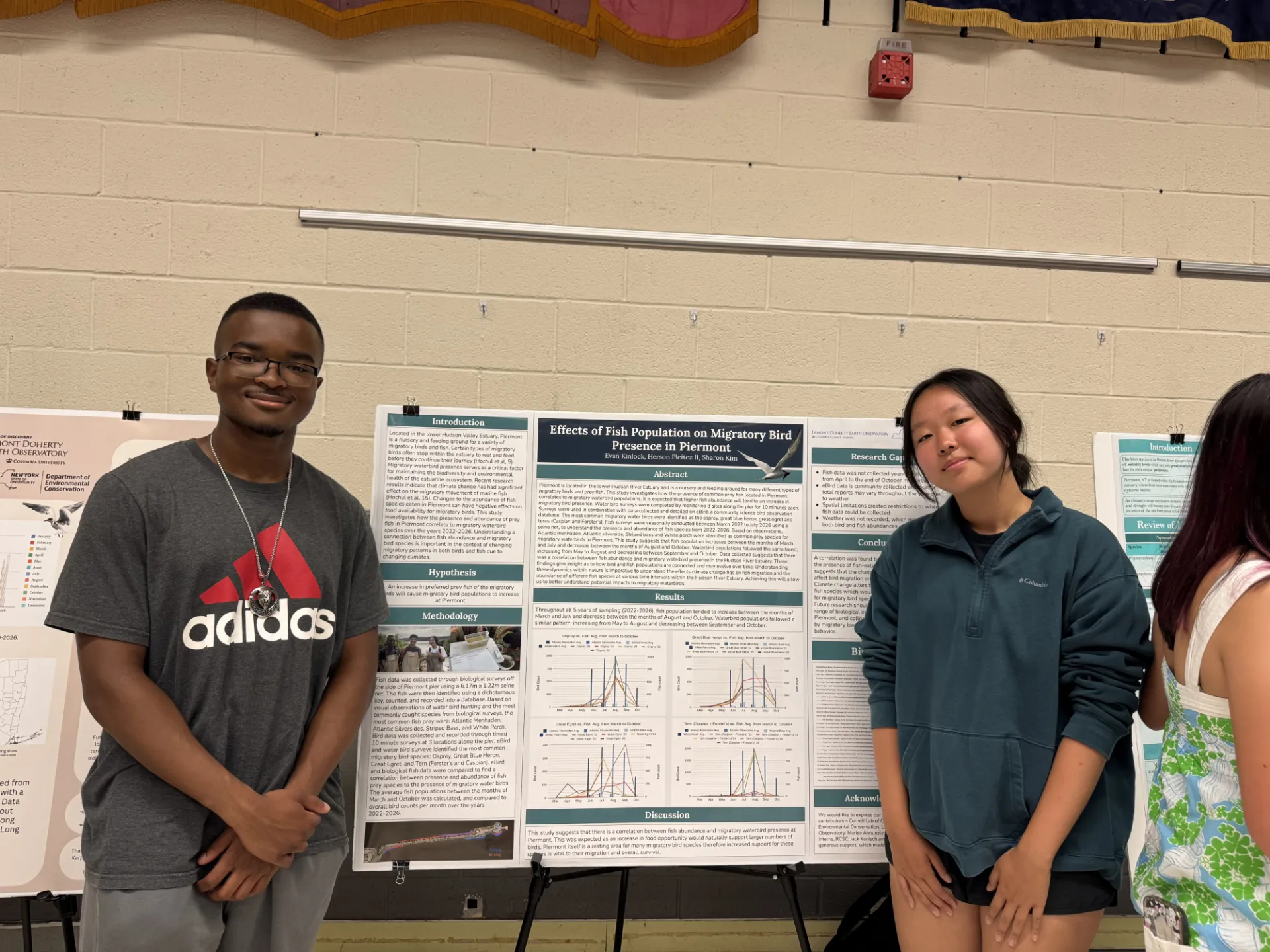 Next Gen interns Sharon and Evan standing in front of their research poster