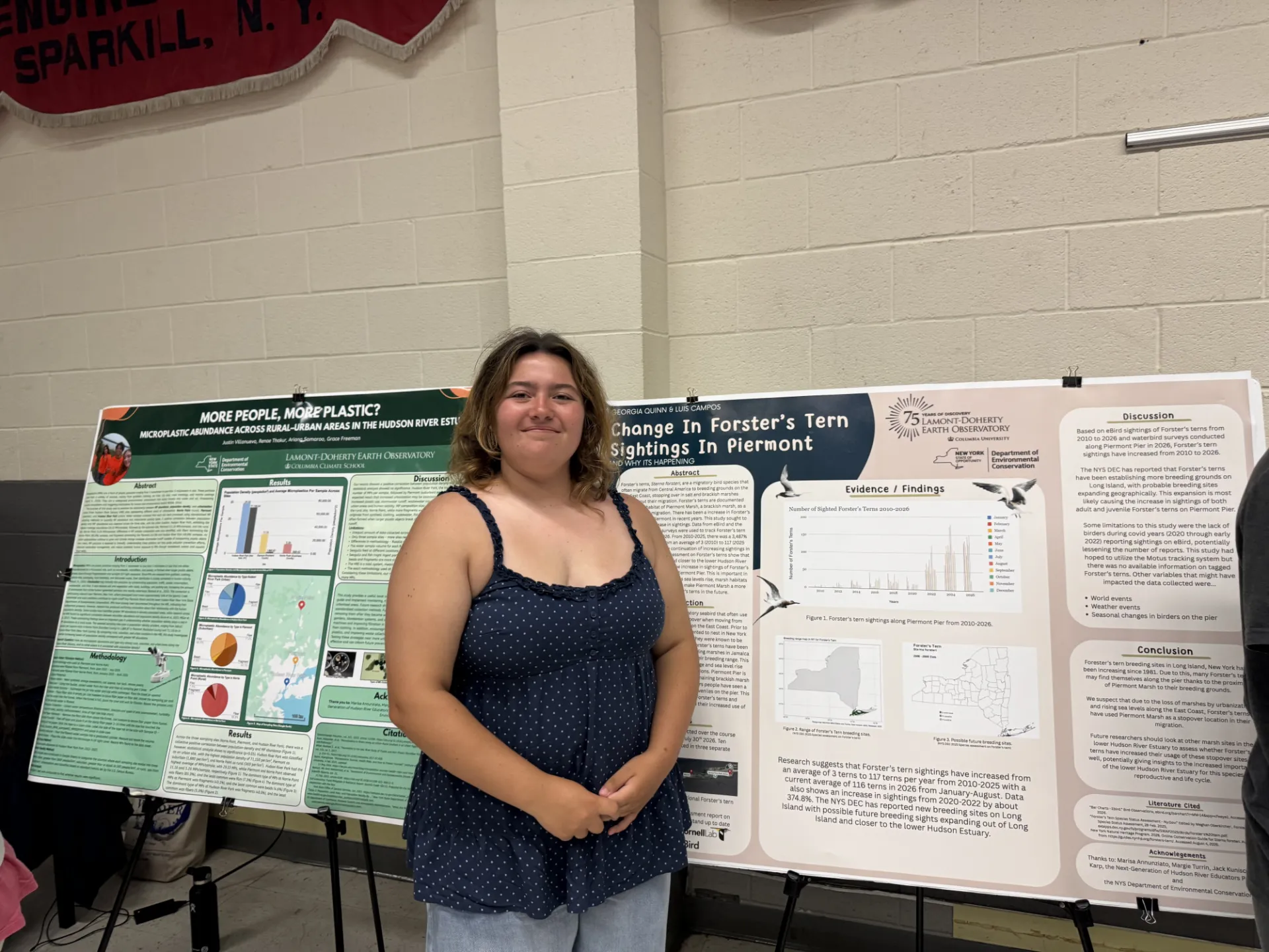 Next Gen intern Georgia standing in front of her research poster 