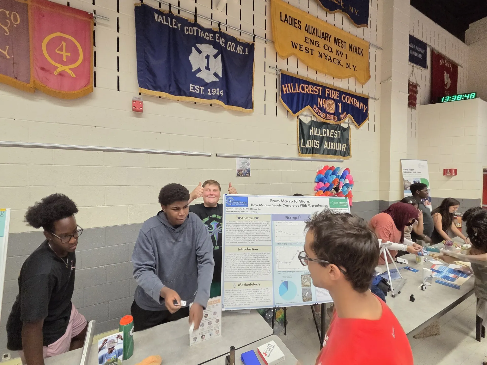 Next Gen Interns standing by research poster “From Macro to Micro."