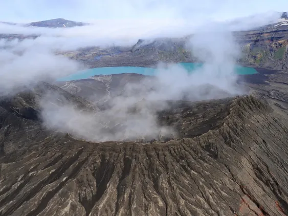 The rim of Cone D—inside the Okmok Volcano caldera—with the blue lake in the background. Credit: Nick Frearson