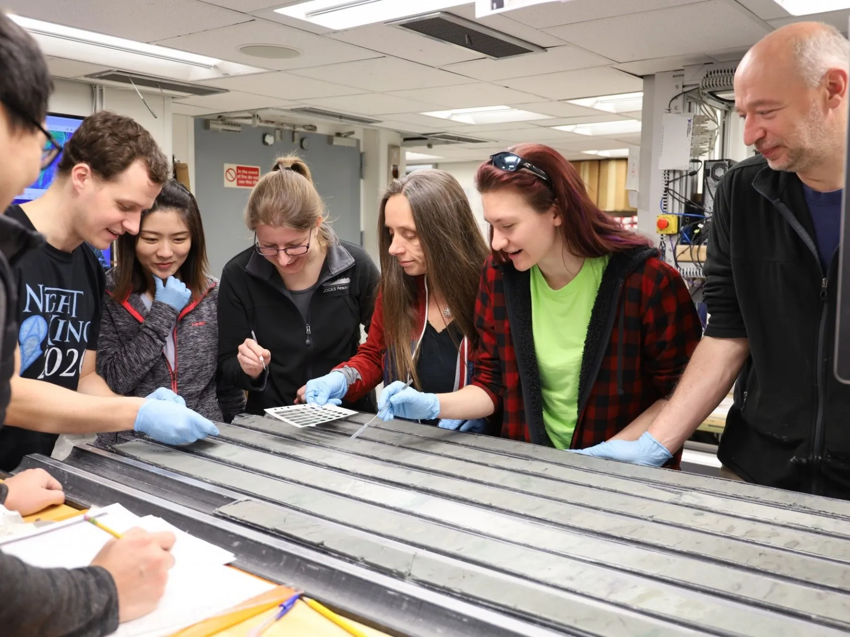 Trace Isotope and Noble Gas Lab at Lamont - Members of Expedition 383 Examine a Freshly Split Sediment Core