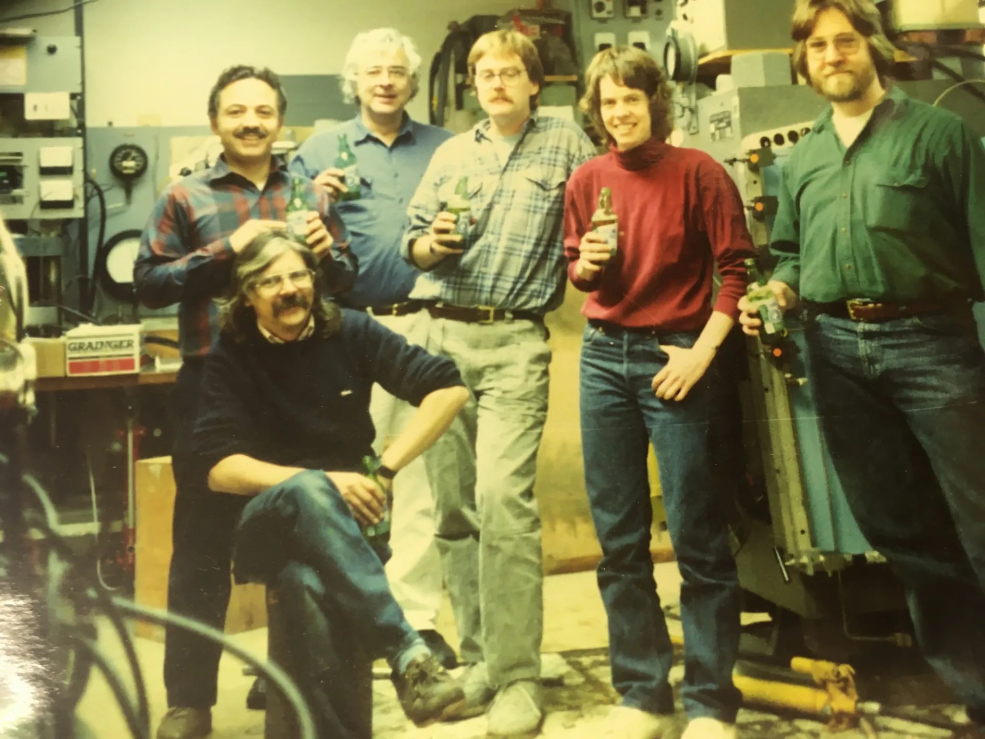 John Longhi, Ted Koczynski, Dave Walker, Chip Lesher, Marie (Krikitt) Johnson, and Peter McNutt enjoying rolling rocks after successfully rolling Walker's large gray press to make room for a larger blue press (1991).