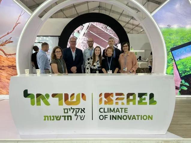 people stand behind a sign that says "israel climate of innovation"