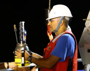 A photograph of oceanographre Ajit Subramniam using marine robotic technology on an ocean research expedition.