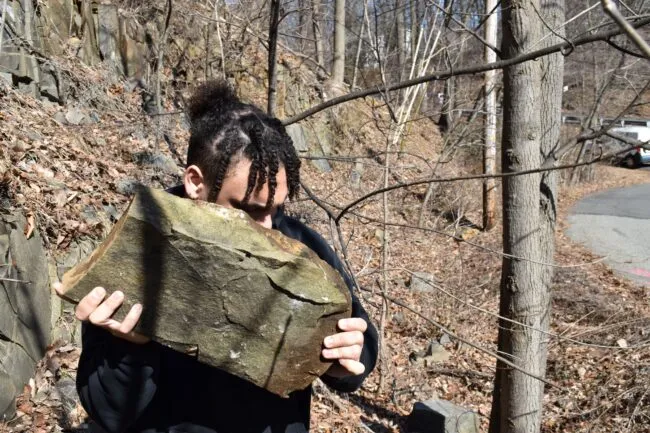 Man carrying a big rock