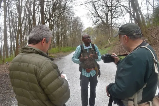 Man talking to two journalists.