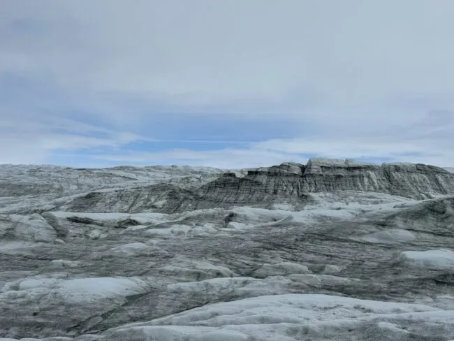 Ice covered by metamorphosed snow (dark in the infrared and invisible to our eyes) and light-absorbing material (soot, dust, algae, etc.)