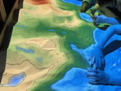 An augmented reality sandbox, where participants could help map the seafloor. Different colors represent different underwater depths.