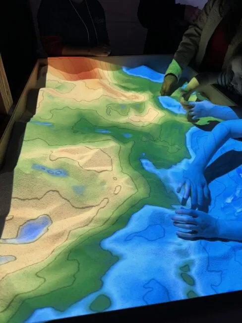 An augmented reality sandbox, where participants could help map the seafloor. Different colors represent different underwater depths.