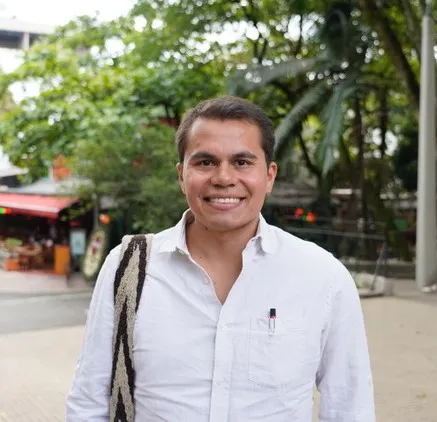 Man stands with tree in background