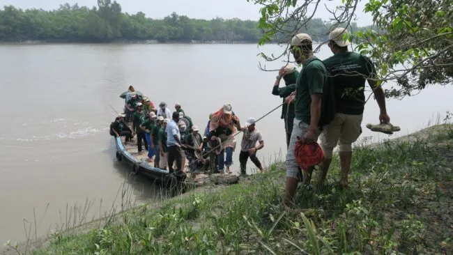 Small boat with group of people being pulled to land