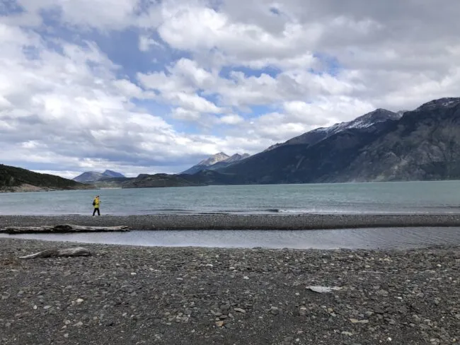 Graduate student Lauren Lewright walking across a pebble beach in Patagonia (March 2024). Credit: Jacky Austermann, Lamont-Doherty Earth Observatory