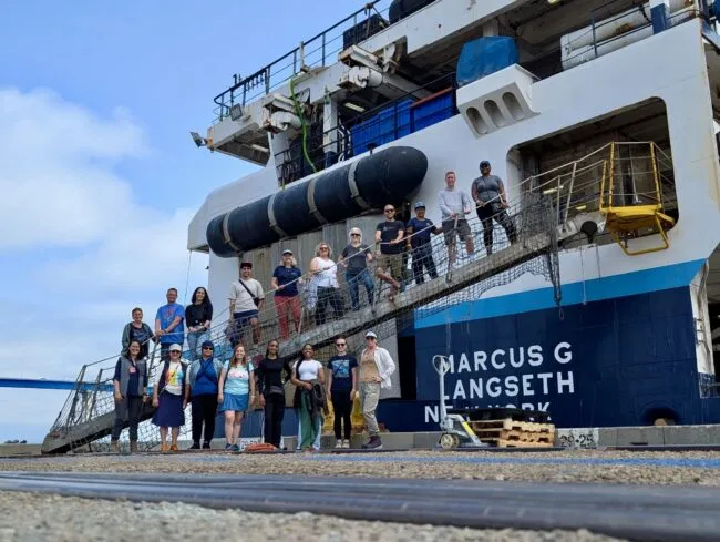 People stand in front of the R/V Langseth