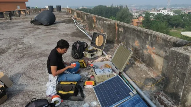 An engineer working to repair equipment on a roof
