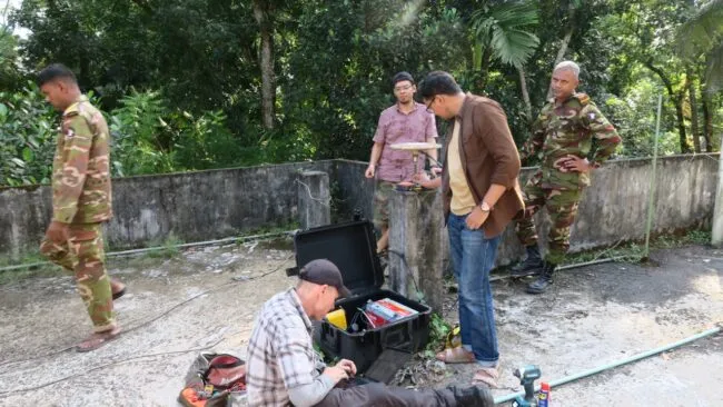 People repairing a global navigation satellite system with army escorts