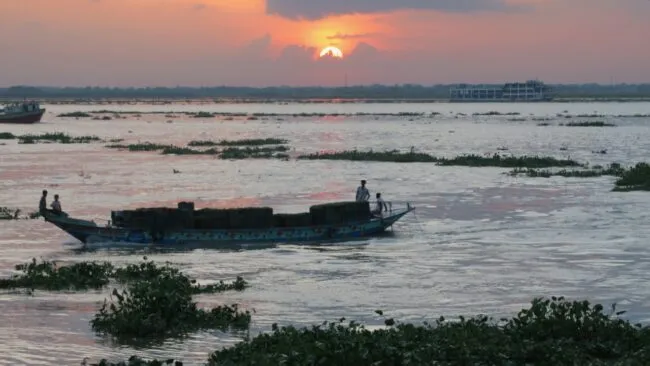 Sunset over a river with a boat and ferry 