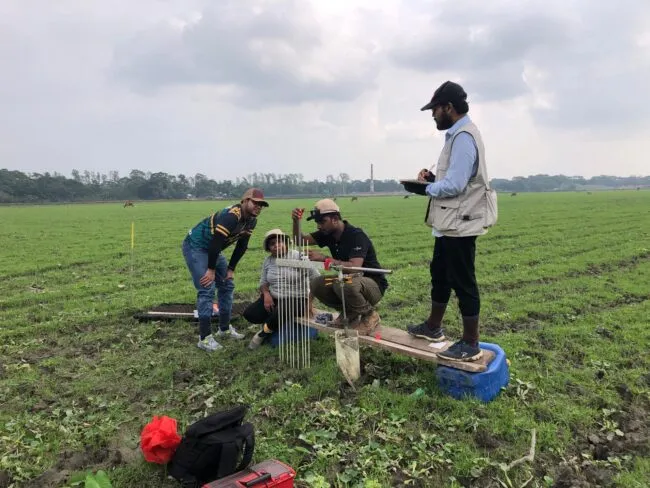 A team takes measurements at a field station