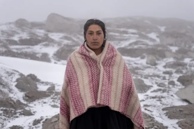 A herder poses for her portrait atop a glacier