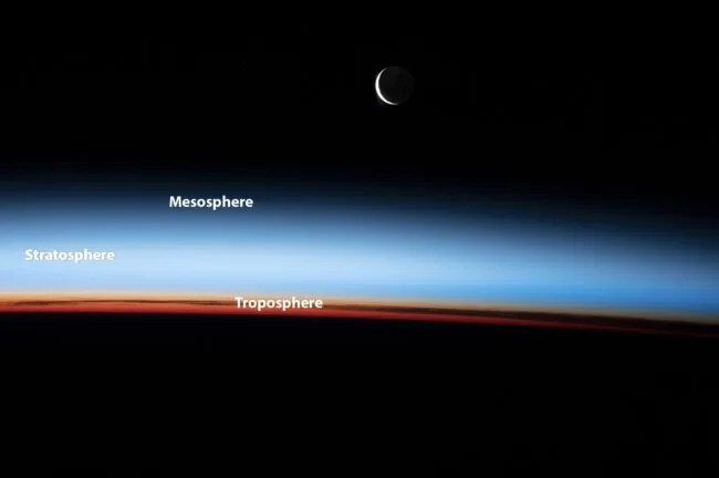 Photo of Earth's limb, with a crescent moom above