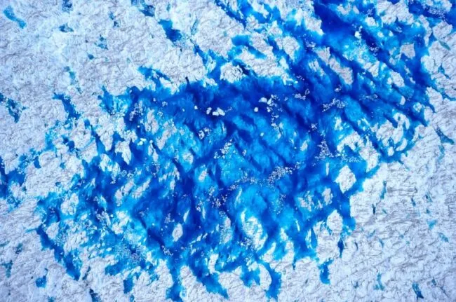 Abstract blue and white textured pattern resembling ice or water, taken from a drone
