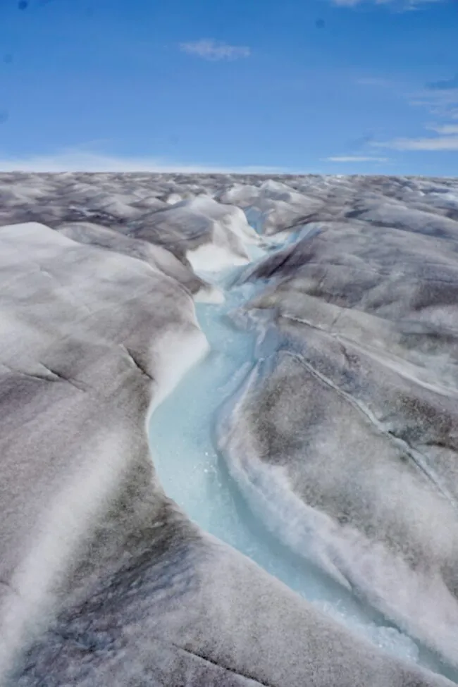 Glacial surface with lake and darkening on ice