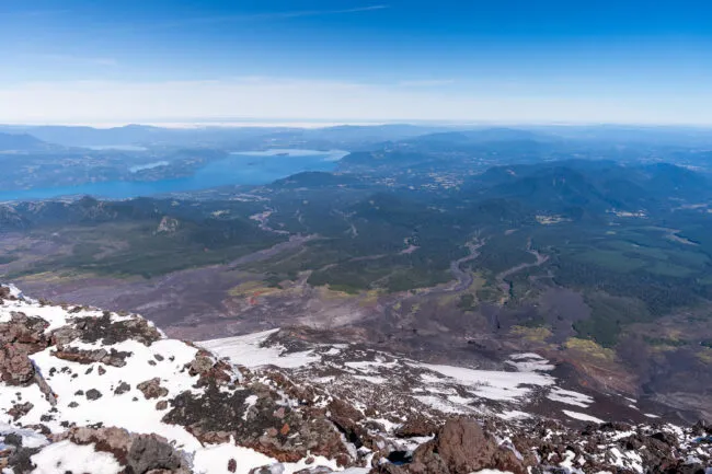 Lahars are fast moving flows of  water, mud and rock. This photo, taken on the southwest side of the rim shows the distance travelled by lahars from a prior eruption. Lake Calafquén is in the distance, approximately 10 miles away. Photo by Francesco