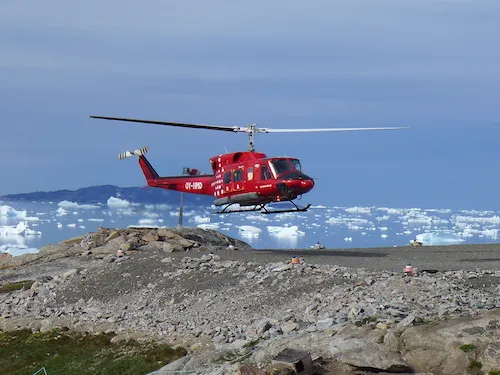 Landing at the Kullorsuaq ‘helipad’. The helipad is surrounded by canisters of gasoline used to refuel for the return leg. The local transport of luggage and gear is a front loader that delivers the gear to your door. (Photo M. Turrin)