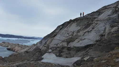 Gabriel and Magnus climb to a high point to get a better view of the  dense ice pack in front of Alison fjord. (Photo M. Turrin)