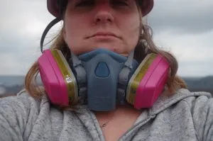 Heavy-duty gas mask at the ready, volcanologist Einat Lev prepares to take close-up images of the Halemaumau crater, home of a roiling lava lake. (Courtesy Matt Patrick, USGS)