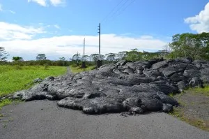 Lava laps across a road near the town of Pahoa. The latest eruption, which started in summer 2014, is not over; it may still overrun larger parts of town.