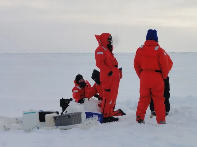 Surface Melt Pond Team collecting water sample. (Photo T. Kenna) 