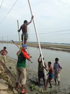 The drillers insert the larger diameter 4" PVC pipe into the well.  Handling the 10 meter pipe is challenging.