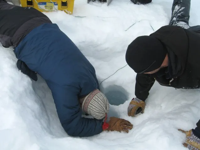 Extracting the sediment core starts with clearing out a hole through the lake's 3-foot-thick ice. (Photo courtesy of William D'Andrea)