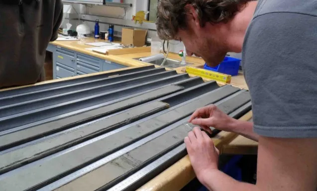 Jeroen van der Lubbe examines the first core brought up by the team aboard the Joides Resolution.
